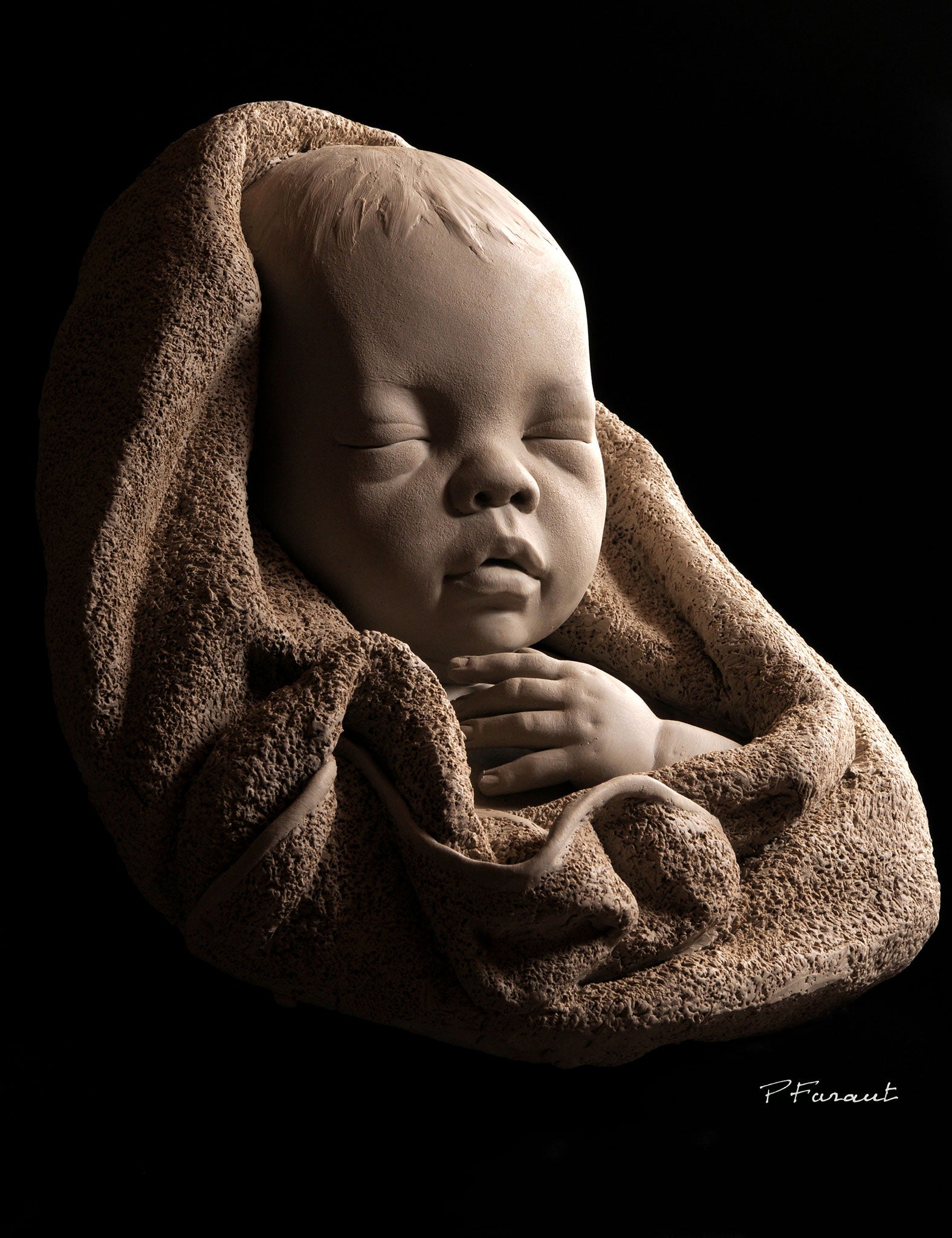 Sleeping baby wrapped in towel sculpture by Philippe Faraut