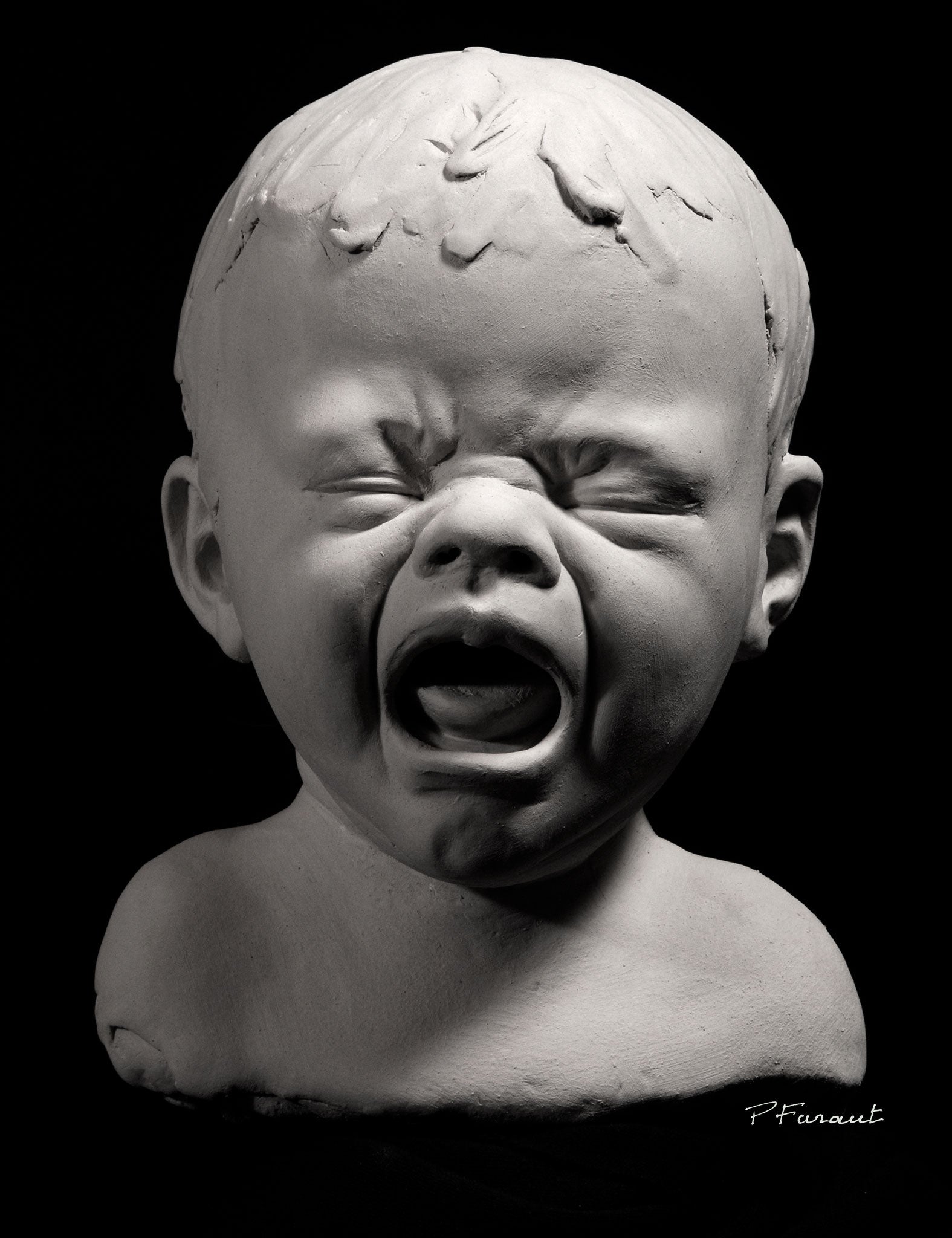 clay portrait of a closed-eyed crying baby by Philippe Faraut